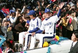 中日の優勝パレードで、沿道のファンに手を振る福留孝介外野手(右)と川上憲伸投手=3日午前、名古屋市中区